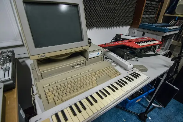 An old white computer monitor and keyboard with nobody sitting at it