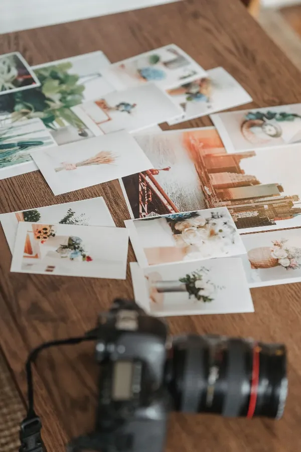 Printed photos scattered across a wooden table