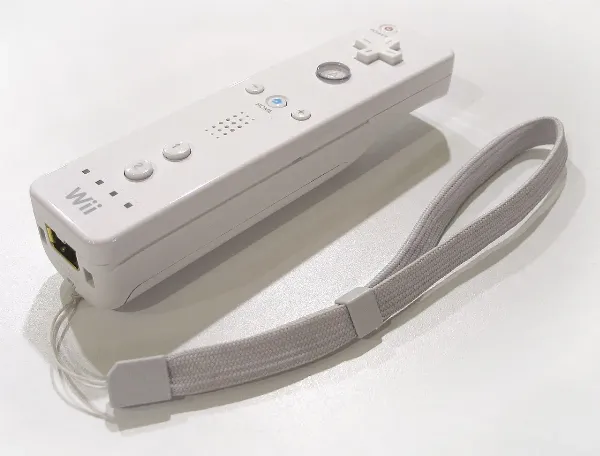 A white Wii Remote with its Nunchuk attachment