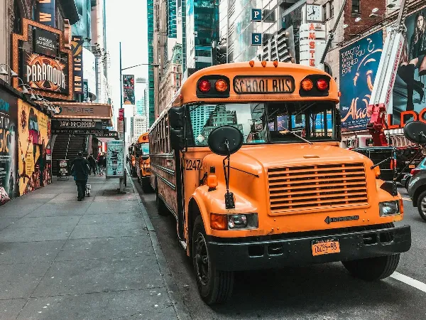 A yellow school bus driving down a city street